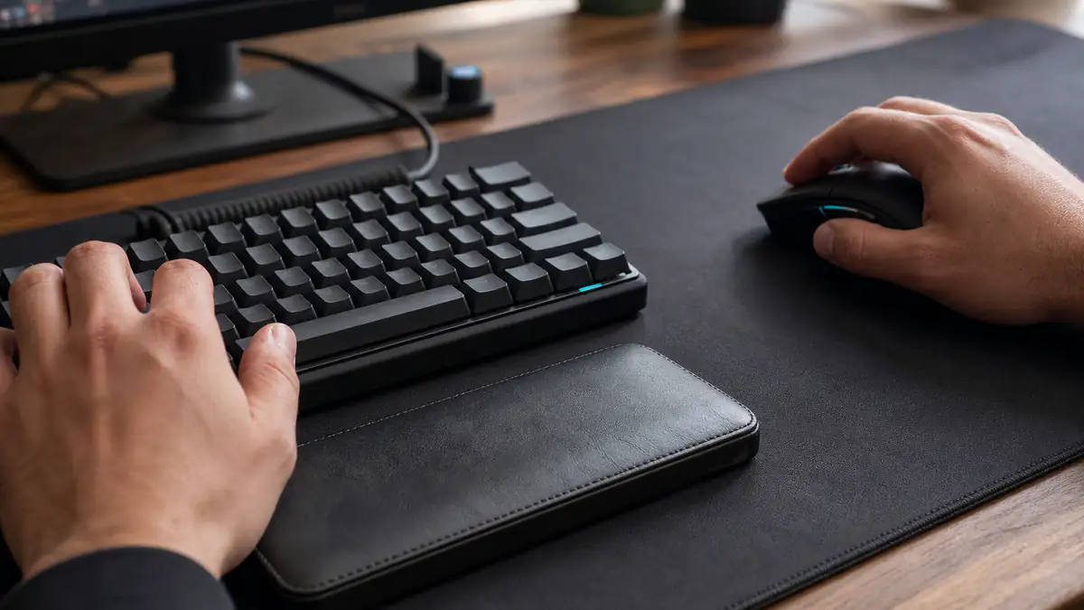 Hands using a compact keyboard and mouse with a wrist rest